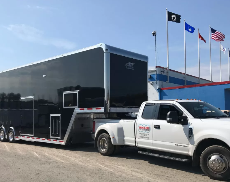 White truck with a black trailer hitched to the back